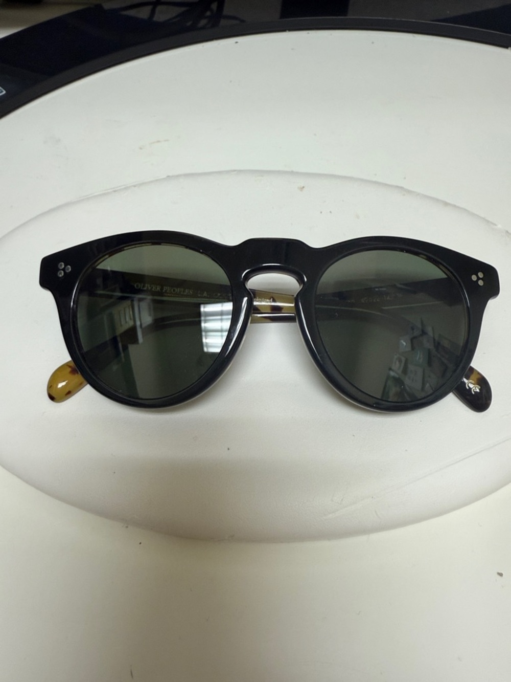 Oliver Peoples Black Round Sunglasses with Tortoiseshell Temples
Learn